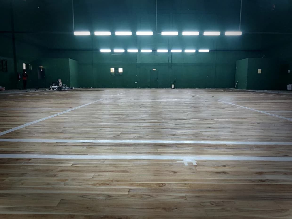 Markings set out on a completed teak court, fixtures lit above